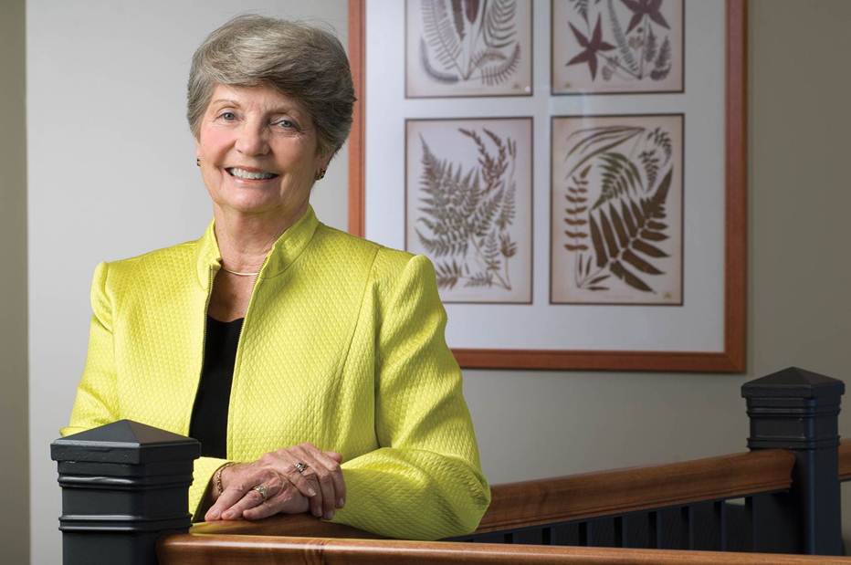 Ann Schiele smiling while posing near a bannister.