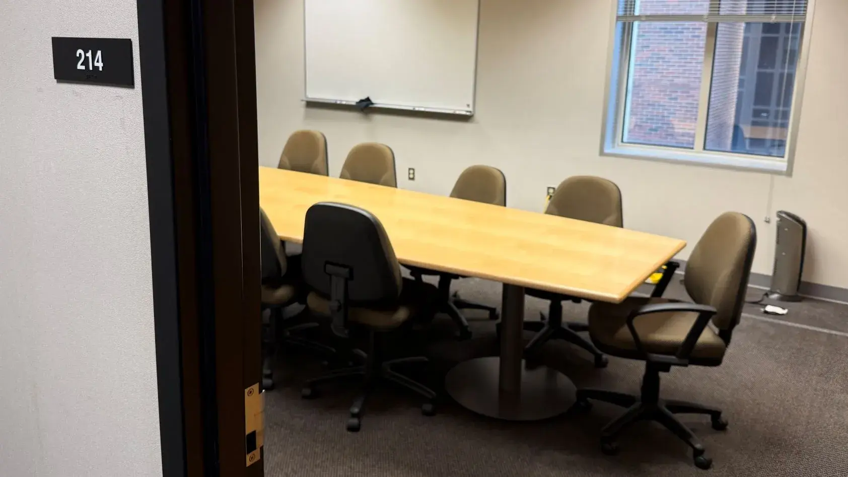 Health Science Library's 214 Interview Room featuring a large conference table and several office chairs.