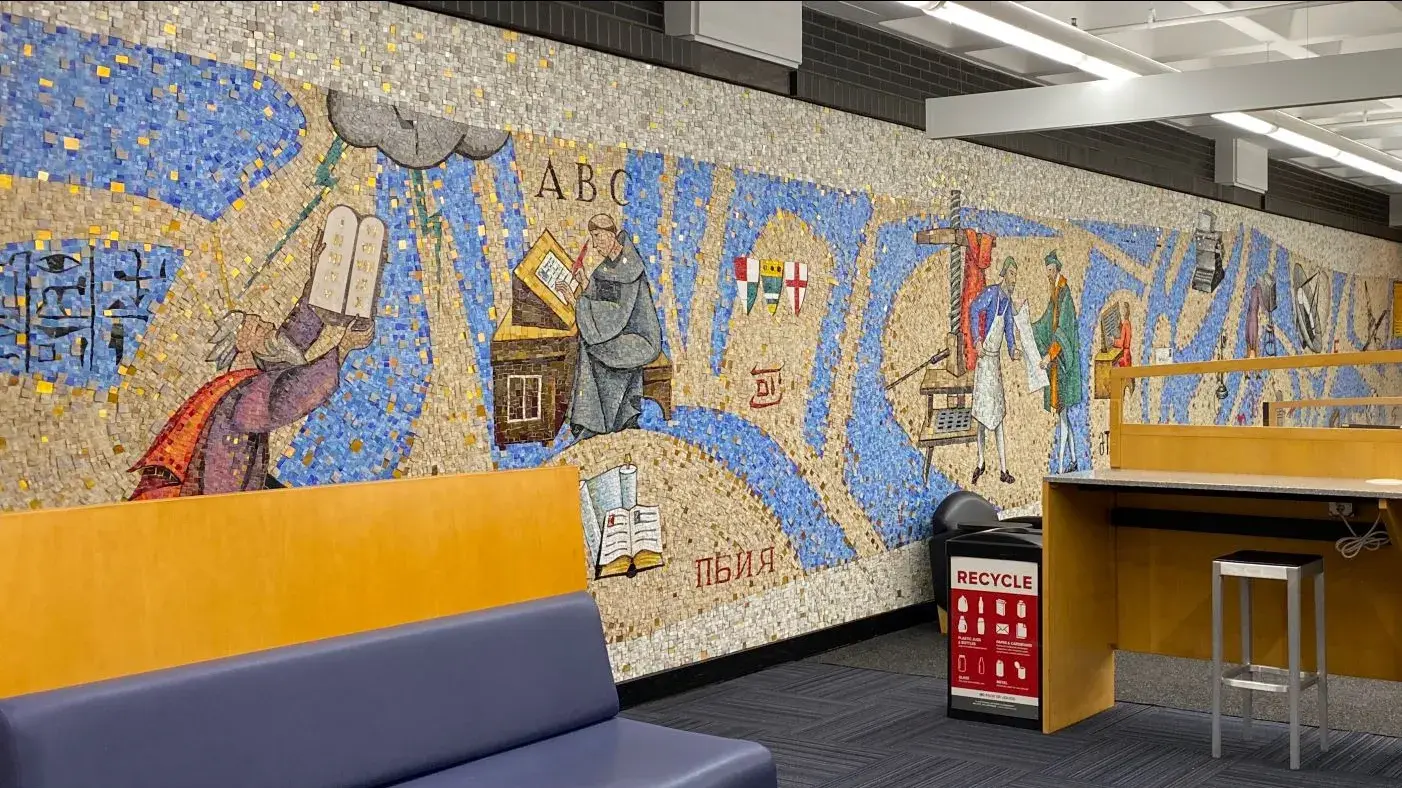 Interior of the Health Science Library featuring a mosaic wall of moments in health science history. 