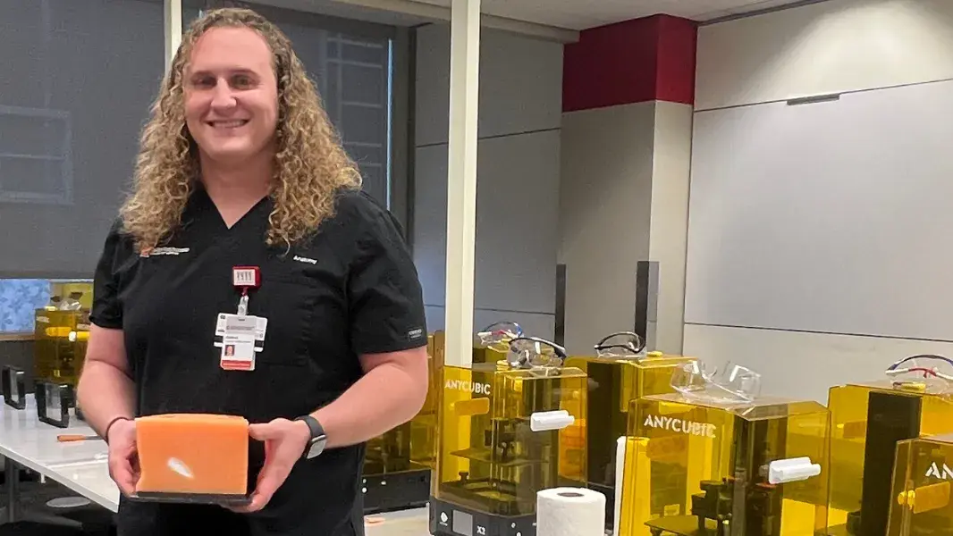 Person standing in front of 3D printers