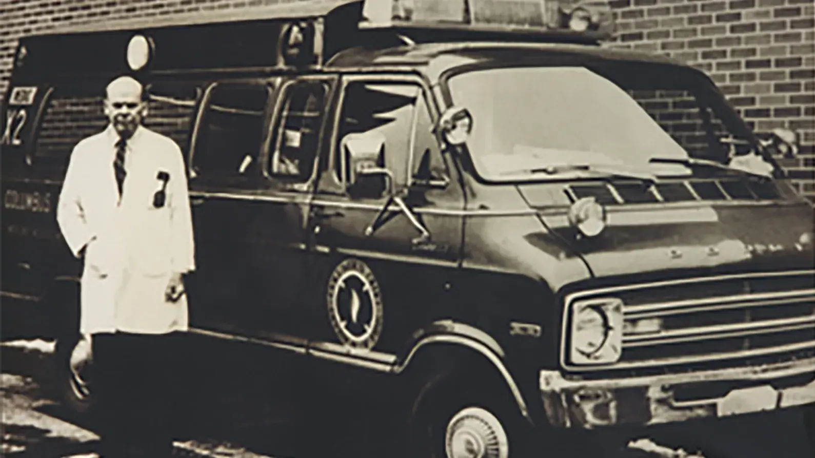 James V. Warren, MD standing against a van