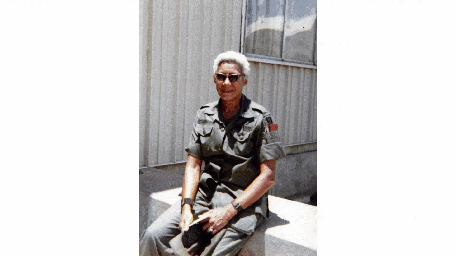 Clotilde Bowen in an army uniform, resting and smiling outdoors.