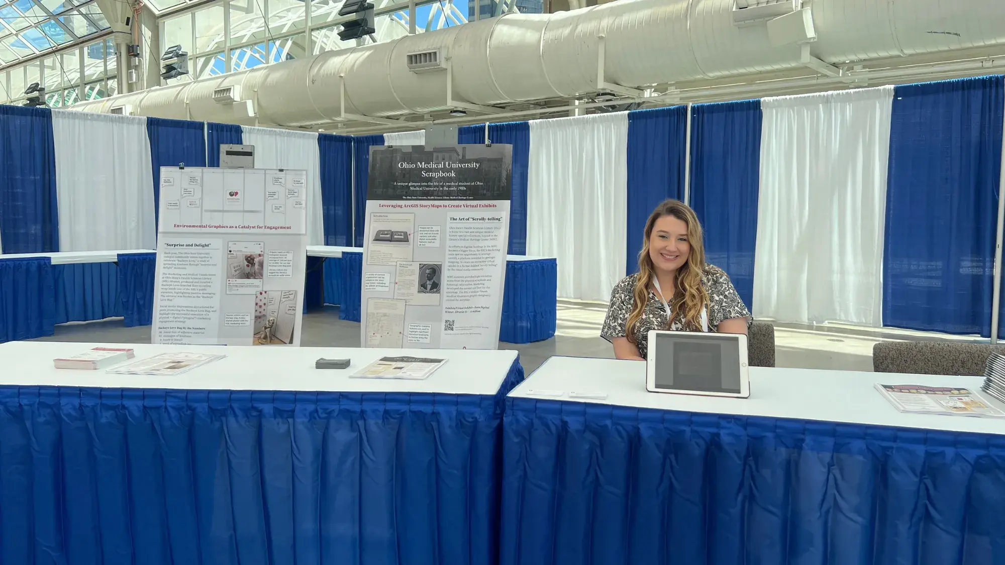 Courtney Chenock smiling at a conference with Medical Visuals' coloring book.