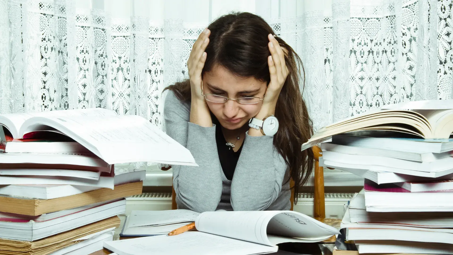 Woman studying, appearing stressed.