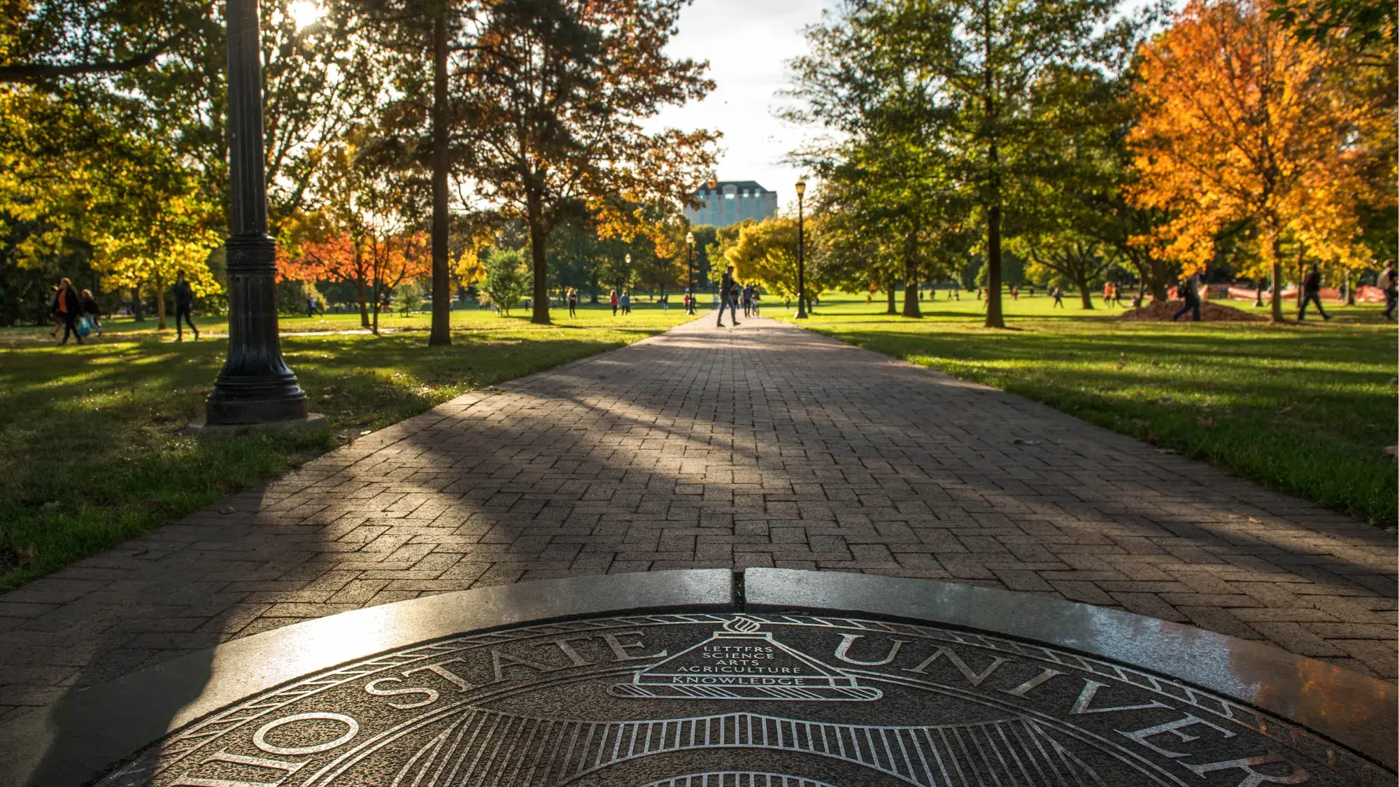 Students walk around The Ohio State University's campus on a sunny day.